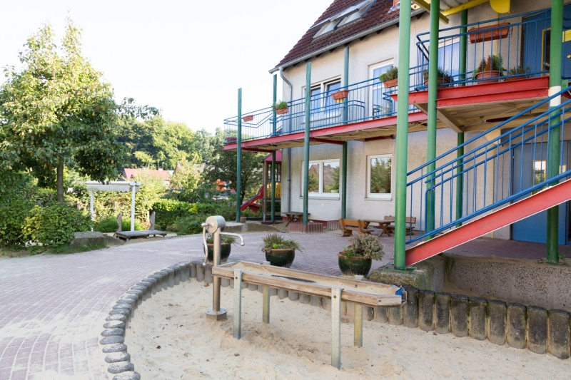 Vorderes Außengelände mit Eingangsbereich und Matschbecken