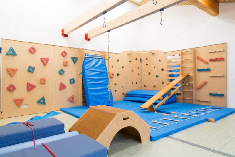 Im Raum der wilden Kerle (Turnhalle) gibt es Kletterwände und ein Schienensystem, welches den Kindern viele Möglichkeiten der Bewegung bietet.
